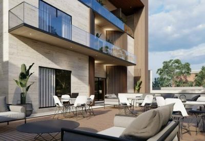 Spacious outdoor terrace with comfortable lounge seating and dining tables surrounded by greenery.