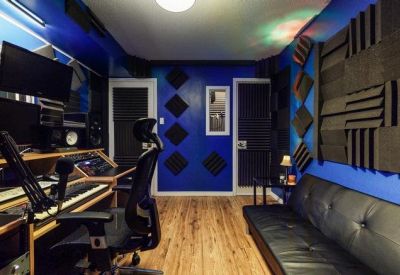 Professional recording control room with blue walls and audio mixing equipment.