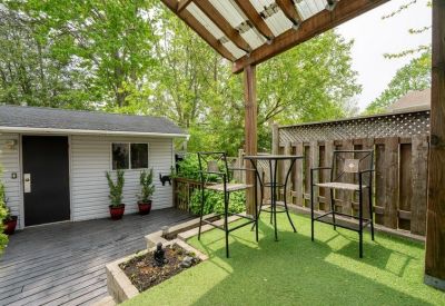 Outdoor patio area with high-top seating and a small garden shed.