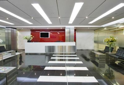 Modern reception desk with a bold red feature wall and polished black floors.