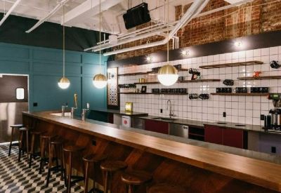 Modern communal bar area with wooden counters and teal walls.