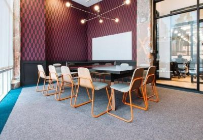 Bright meeting room with patterned purple wallpaper and glass walls.