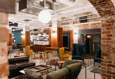 Spacious lounge with eclectic seating and exposed brick walls.