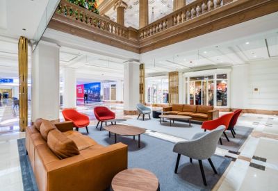 Grand lobby and reception area with marble pillars, ornate ceilings, and leather sofas.