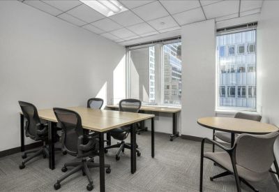 Bright office space with a four-person desk and a separate round meeting table.