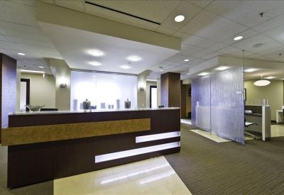 Modern reception desk with dark wood finish and sleek lighting.