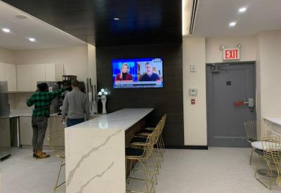 Communal kitchen area with marble breakfast bar and gold-tone stools.