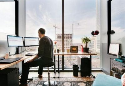 Private office workstation with dual monitors facing a large window with city views.