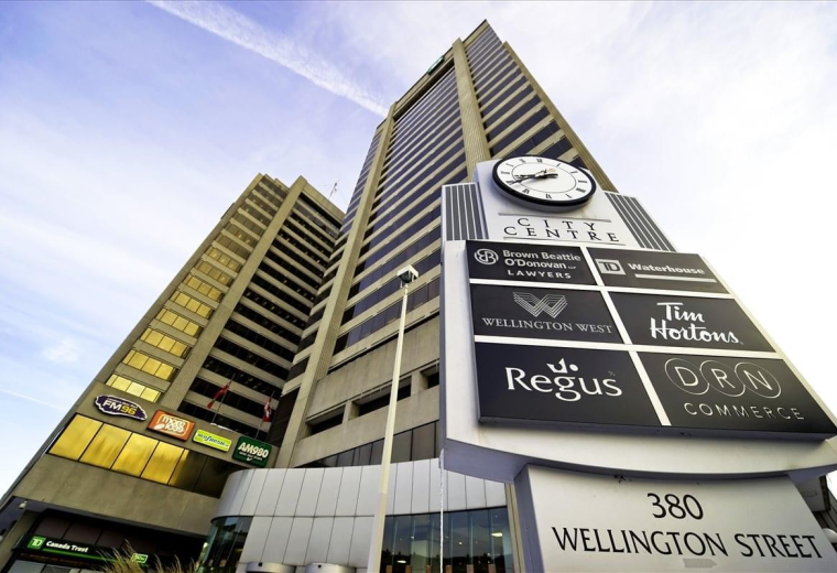 Exterior shot of the high-rise 380 Wellington Street, Tower B building with a large clock and tenant directory.