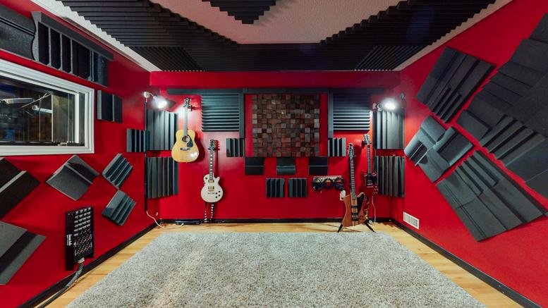 Spacious music studio at 10 Lisa Court, London (Ontario) with red walls and various guitars.
