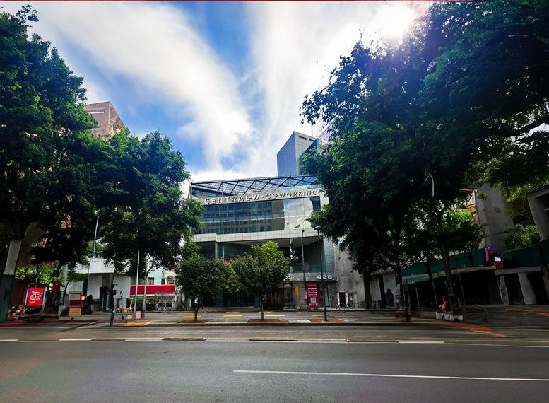Street view of a modern office building with trees around.