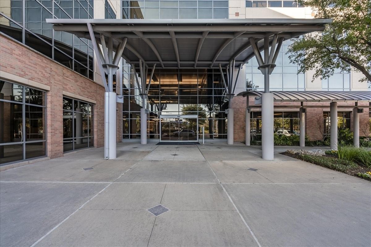 Building entrance of 13785 Research Boulevard, Suite 125, featuring a large metal canopy and glass facade.