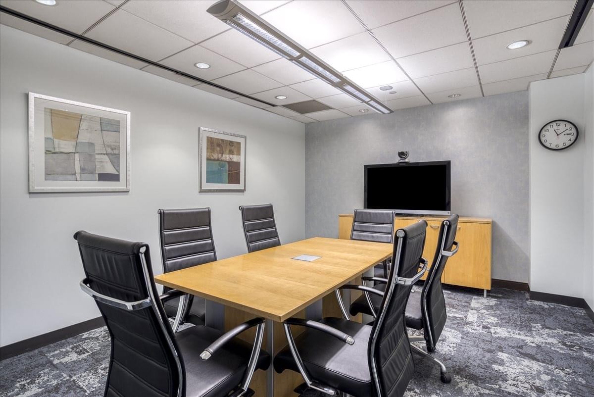 Professional meeting room at 260 Madison Avenue featuring a wood table and black leather chairs.