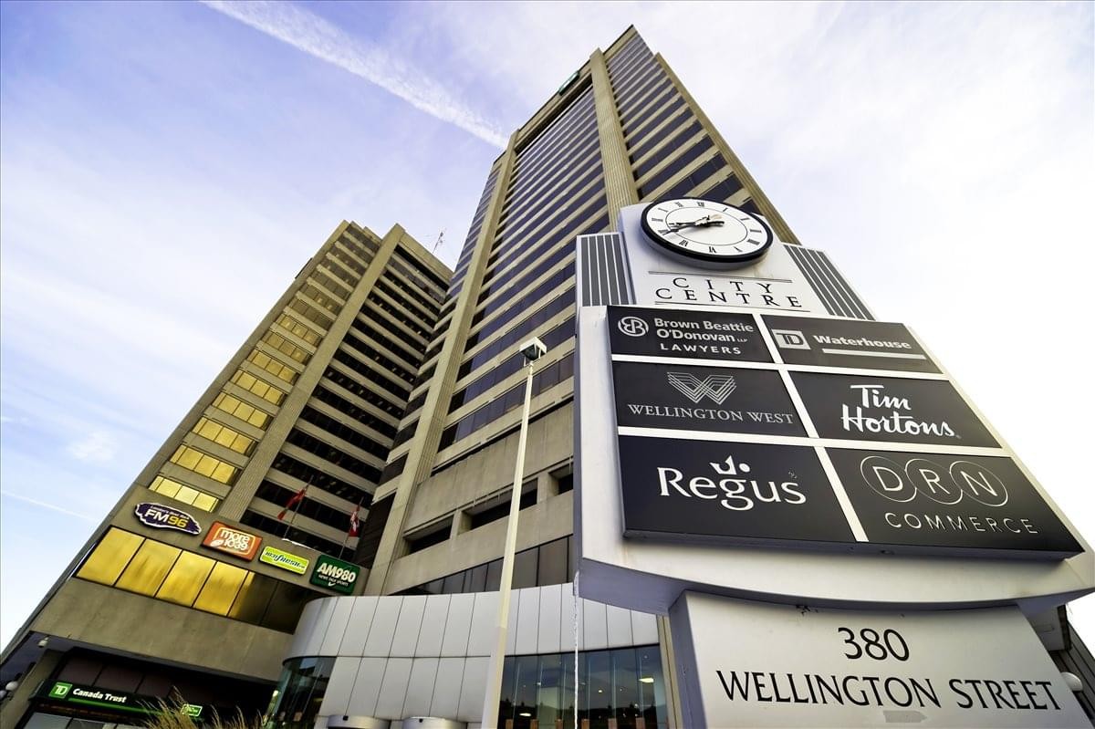 Exterior shot of the high-rise 380 Wellington Street, Tower B building with a large clock and tenant directory.