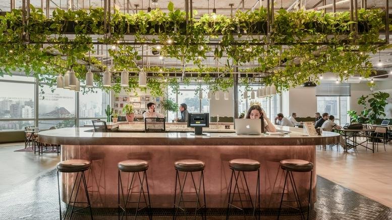 Spacious communal lounge at Torre Norte 12901 featuring a copper bar, stools, and hanging plants.