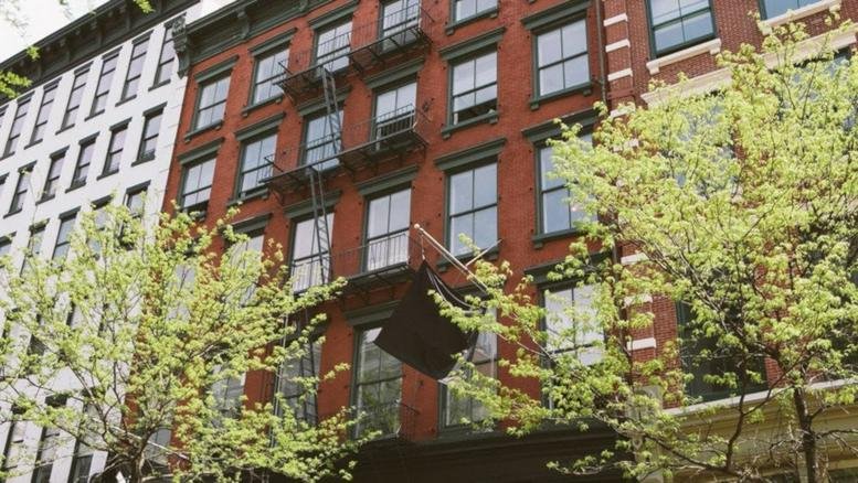 Red brick exterior facade of the building at 379 West Broadway with classic fire escapes.