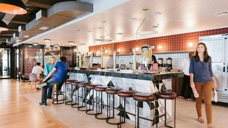 Spacious communal bar and café area at Rua Flórida, 1970, Brooklin, Sao Paulo with modern stools and warm lighting.
