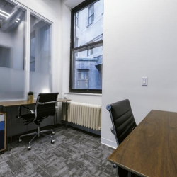 Private two-person office suite with a large window and wood-topped desks.