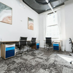 Bright multi-desk office with abstract wall art and ergonomic seating.