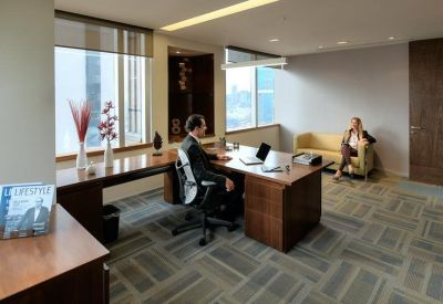 Private office suite with dark wood desk and city view.