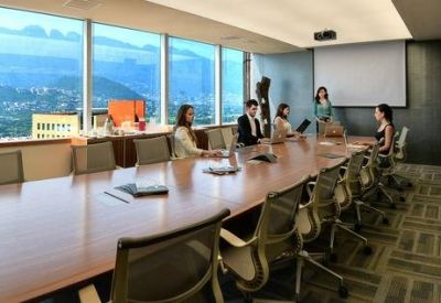 Large boardroom featuring a long wooden table and mountain views.