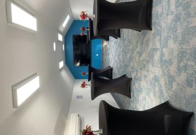 Breakout area with tall bistro tables and blue accent wall.