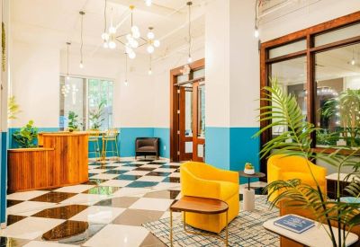 Vibrant lounge with yellow armchairs and a black and white checkered floor.