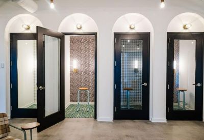Private phone booths with arched entries and patterned wallpaper.
