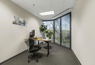 Private office suite featuring a height-adjustable desk and large corner window.