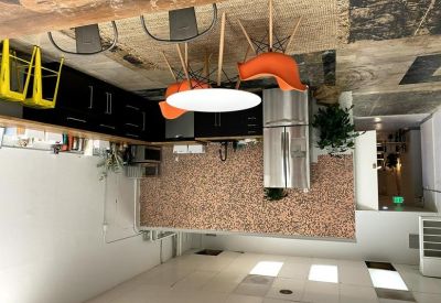 Modern communal kitchen at 122 East Main Street, Downtown, Medford, Oregon featuring dark cabinetry and a penny tile wall.