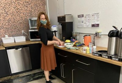 Kitchen counter area with black cabinetry, a coffee station, and colorful accents.