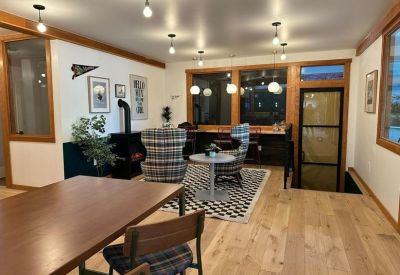 Collaborative workspace with plaid lounge chairs, a wooden dining table, and large windows.