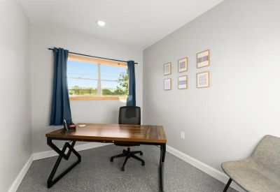 Reception area with light grey floors, comfortable seating, and a view into the office space.