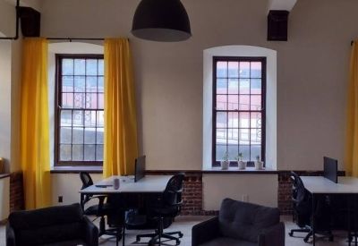 Bright office space with two white desks and vibrant yellow window curtains.
