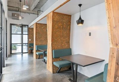 Private work booths with wood-panelled walls and blue upholstered seating.