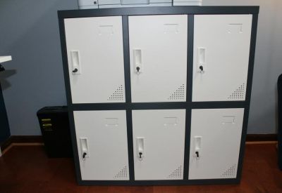 Set of six white storage lockers with individual key locks in a grey frame.