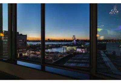 Window view overlooking the Hudson River and city skyline at dusk.