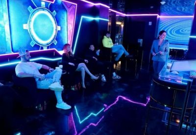 Modern lounge with neon blue and purple light strips and a circular wall feature.