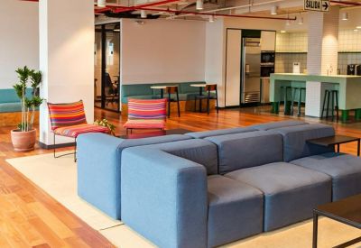 Lounge area with a blue sofa and kitchen in the background