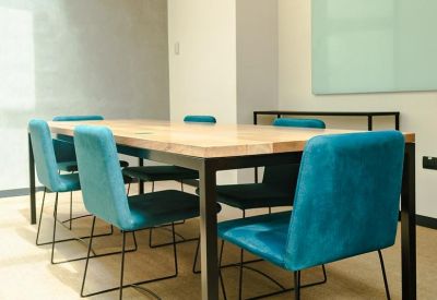 Meeting room with a wooden table and turquoise chairs