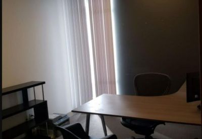 Private office suite with a wooden desk and black designer chairs.