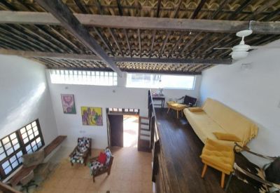 High-angle view of a lofted lounge area with a yellow sofa and wooden ceiling beams.