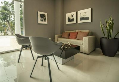 Lounge area with a comfortable cream sofa, grey armchairs, and a modern coffee table.