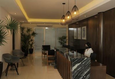 Professional reception area with a marble desk, warm lighting, and potted plants.
