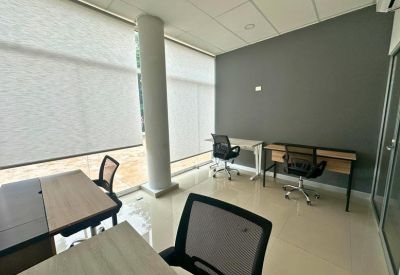 Private office with two desks, ergonomic chairs, and large windows with blinds.