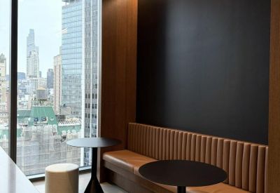 Built-in leather banquette seating with small round cafe tables and city vistas.
