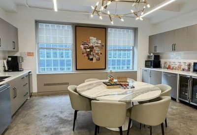 Kitchen and dining area featuring a round marble table and a designer light fixture.