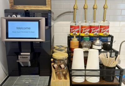 Fully equipped coffee bar with professional espresso machine and flavored syrups.