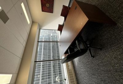 Private executive office with a large wooden desk and abstract wall art.