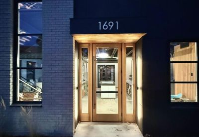 Glass-paneled wood-framed entrance door under the building address 1691.